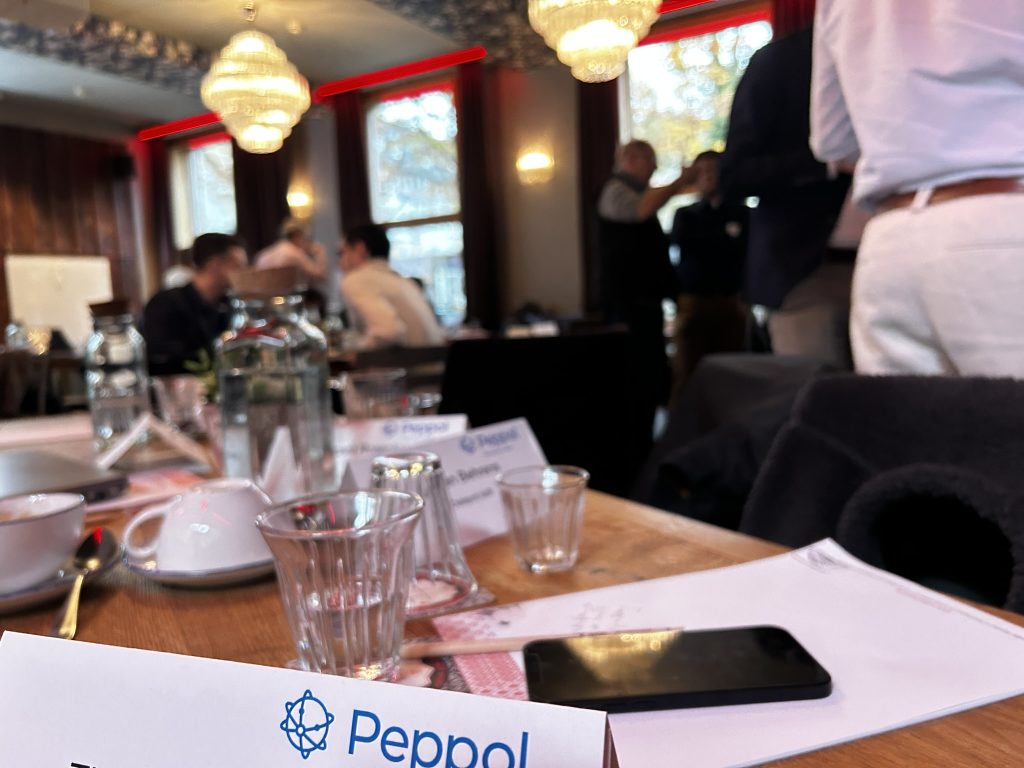 Ein Foto vom Netzwerkmeeting mit dem Logo von Peppol auf einem Namensschild im Vordergrund.